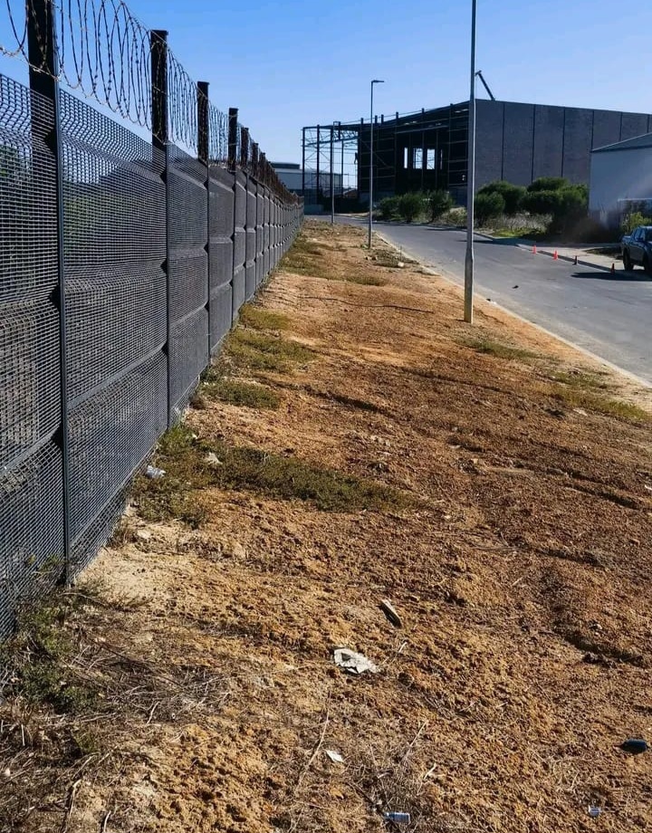 Industrial verge fully cleared of overgrowth along a fence line